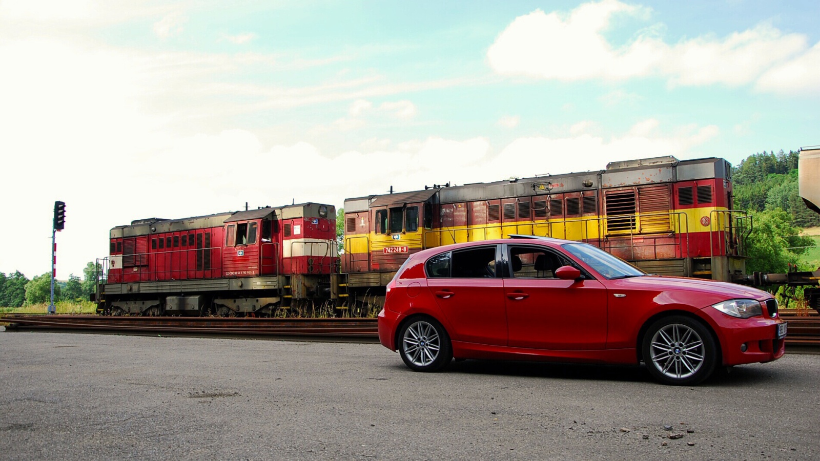 Červené BMW 120d E87 u dvou dieselových lokomotiv